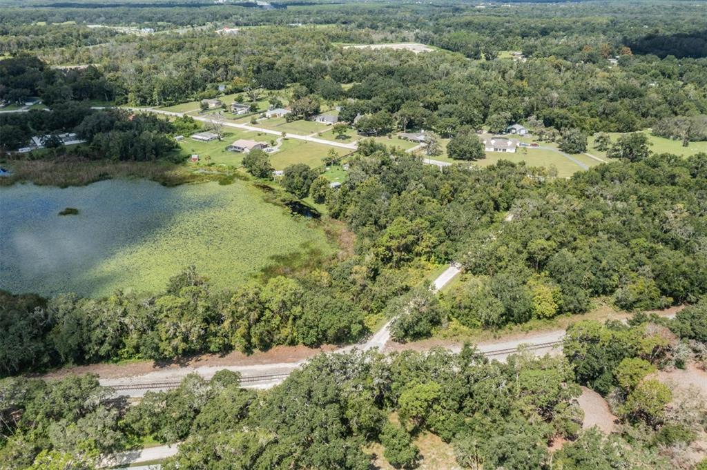 an aerial view of residential houses with outdoor space and trees