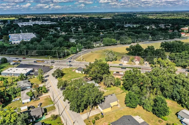 an aerial view of a residential apartment building with a yard and large trees
