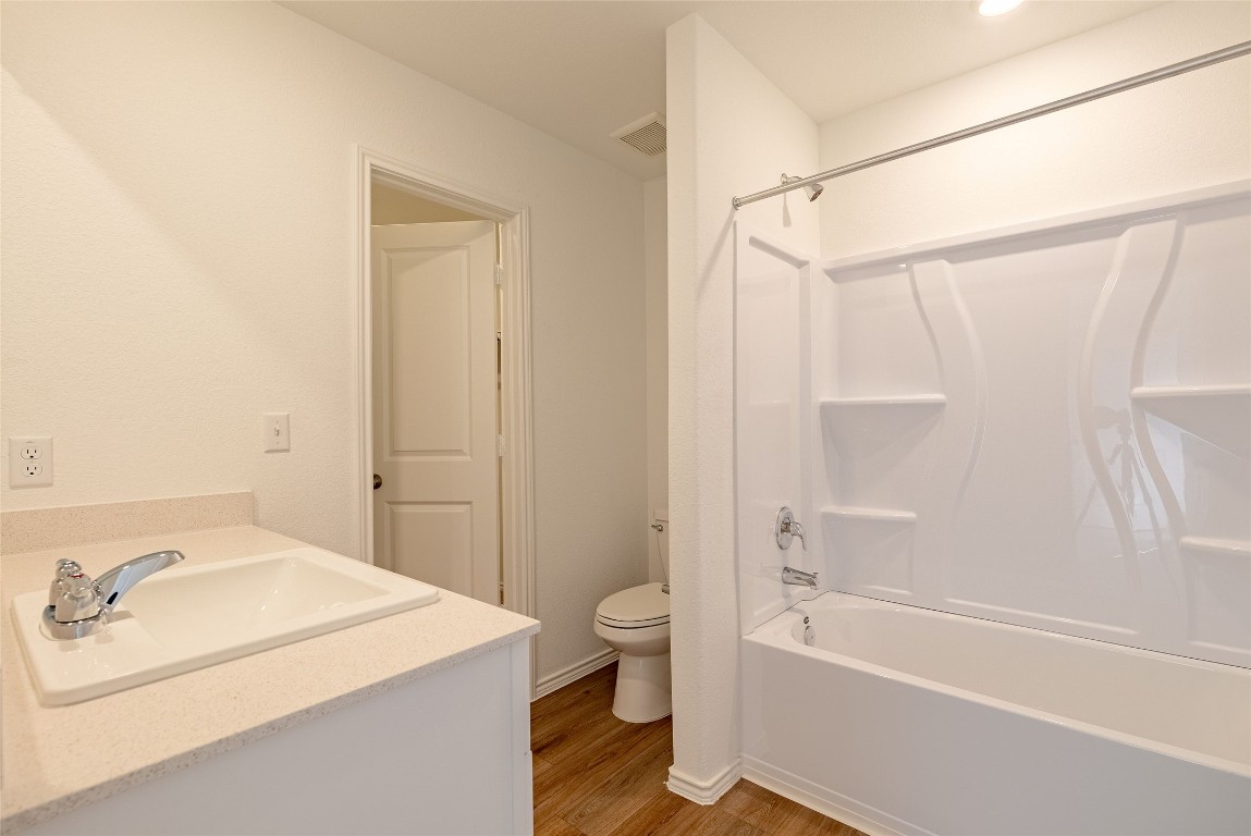 2509 Willkomen Way Pflugerville, TX 78660 - Photo 17 of 20 Full bath featuring vanity, light wood-style floors, and shower / tub combination
