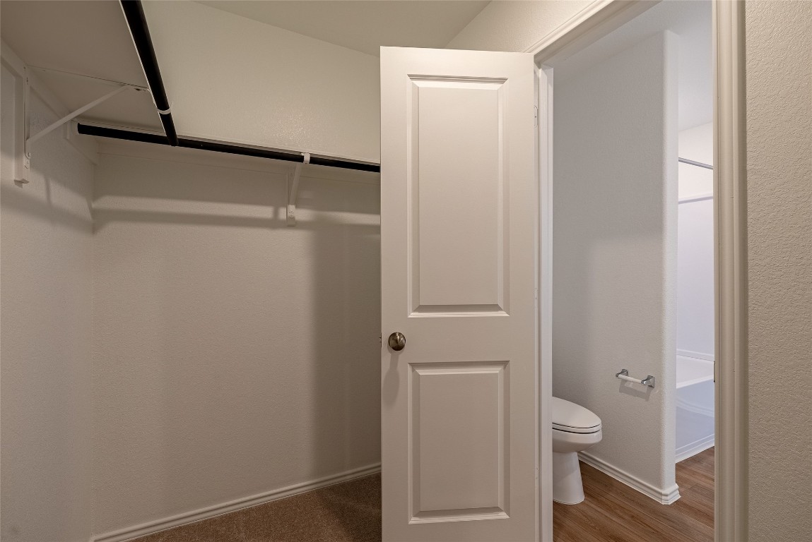 2509 Willkomen Way Pflugerville, TX 78660 - Photo 18 of 20 Walk in closet featuring dark wood-style floors
