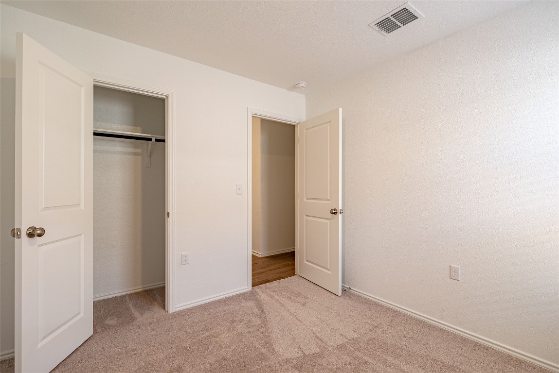 2509 Willkomen Way Pflugerville, TX 78660 - Photo 8 of 20 Unfurnished bedroom featuring light colored carpet and a closet