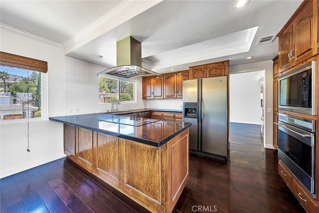 416 Meadowview Drive La Canada Flintridge, CA 91011 - Photo 8 of 35 a kitchen with stainless steel appliances granite countertop a refrigerator a stove and a wooden floors