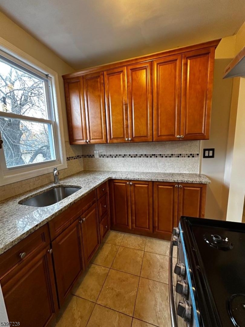 33 Hayward Place, Unit 2 Wallington, NJ 07057 - Photo 1 of 9 a kitchen with a sink a stove cabinets and a window
