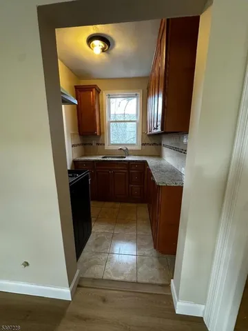a large kitchen with wooden floor and stainless steel appliances