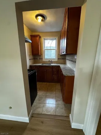 a large kitchen with wooden floor and stainless steel appliances