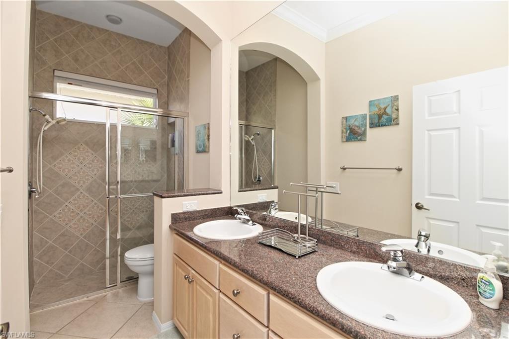 1901 Winding Oaks Way Naples, FL 34109 - Photo 14 of 21 a bathroom with a granite countertop sink toilet and shower