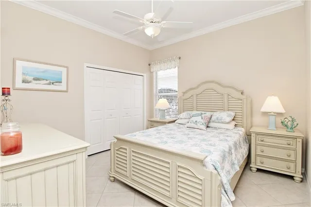 a bedroom with a bed a dresser and a chandelier