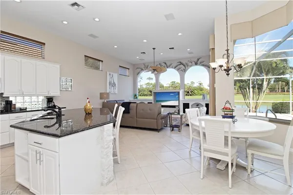 a kitchen with stainless steel appliances granite countertop a stove a sink dishwasher a dining table and chairs with wooden floor