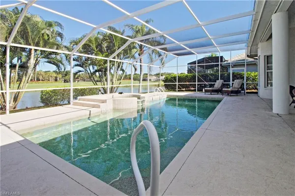 a view of a swimming pool with a patio and a yard