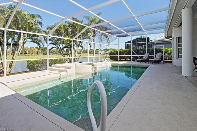 a view of a swimming pool with a patio and a yard