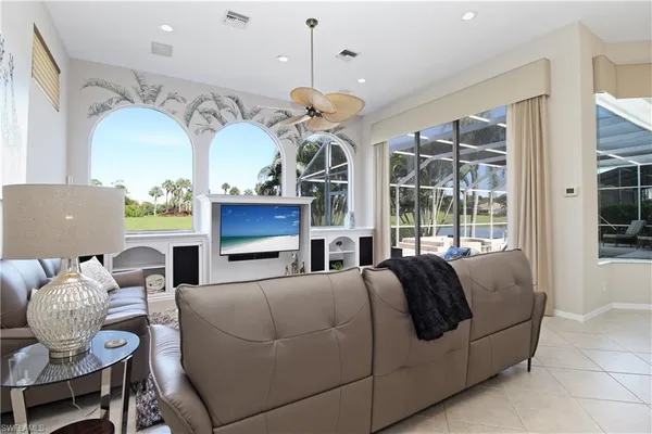 a living room with furniture a fireplace and a chandelier