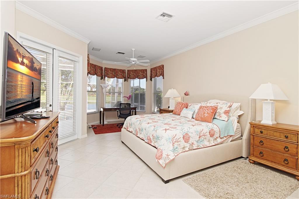 1901 Winding Oaks Way Naples, FL 34109 - Photo 10 of 21 a bedroom with a bed and a flat tv screen on dresser
