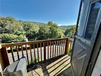 a view of a balcony with wooden floor and fence