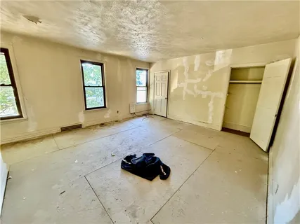 a living room with a table chairs and a refrigerator
