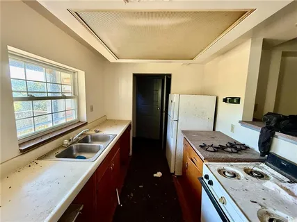 a kitchen that has a sink a stove and a table