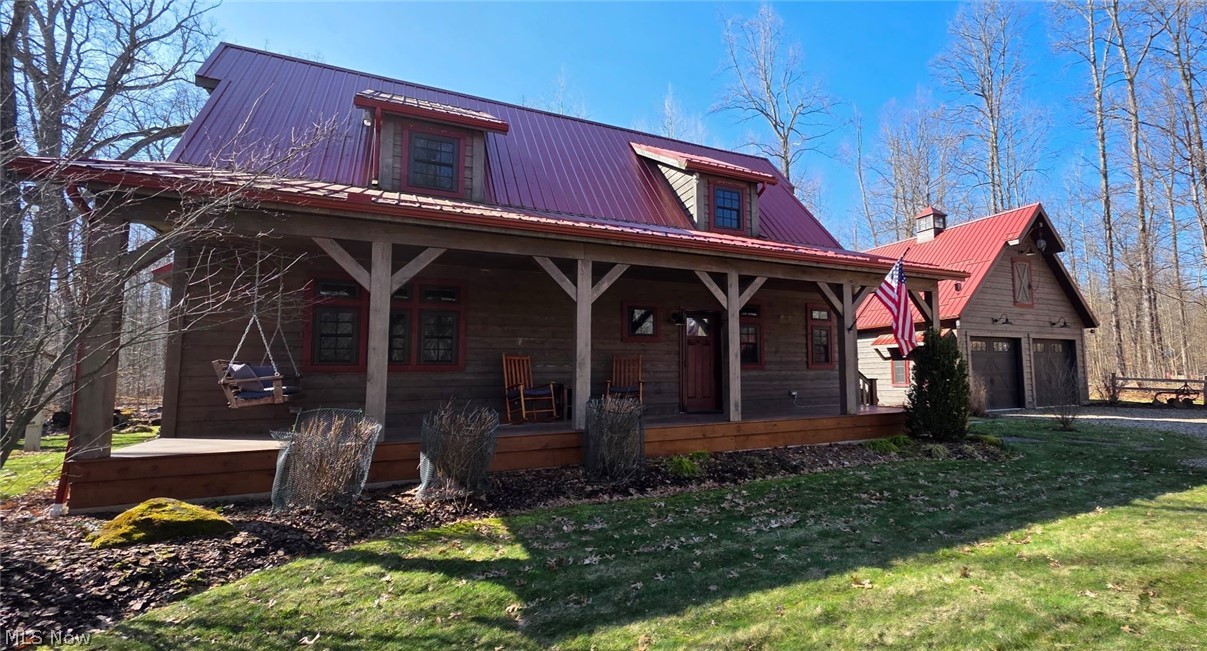 3989 Court Road Wakeman, OH 44889 - Photo 1 of 36 View of front of property with covered porch, a metal roof, a garage, and a front yard