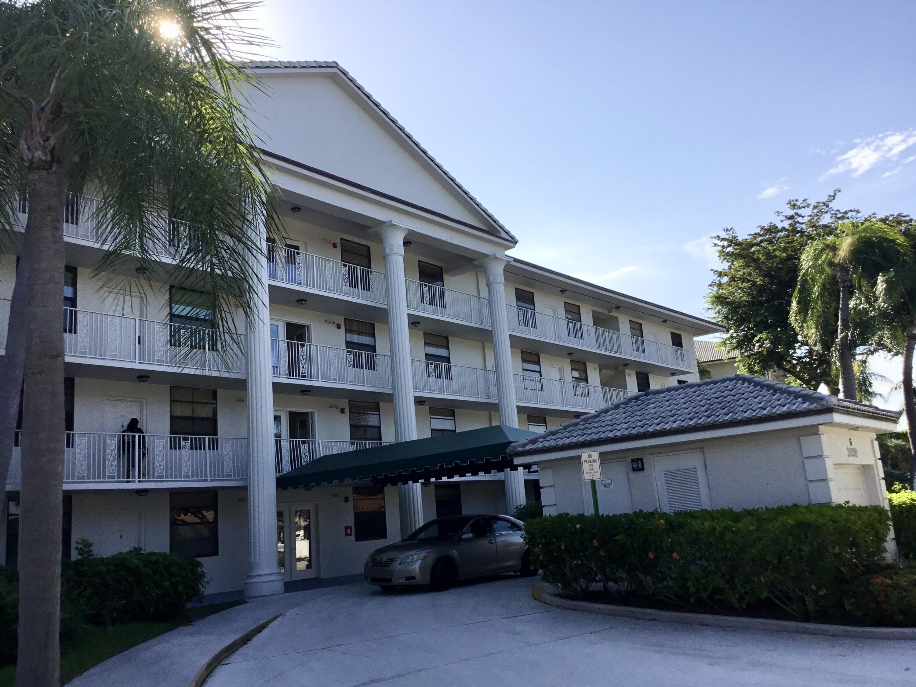 3636 Whitehall Drive, Unit 101 West Palm Beach, FL 33401 - Photo 1 of 16 a front view of a house with a garden