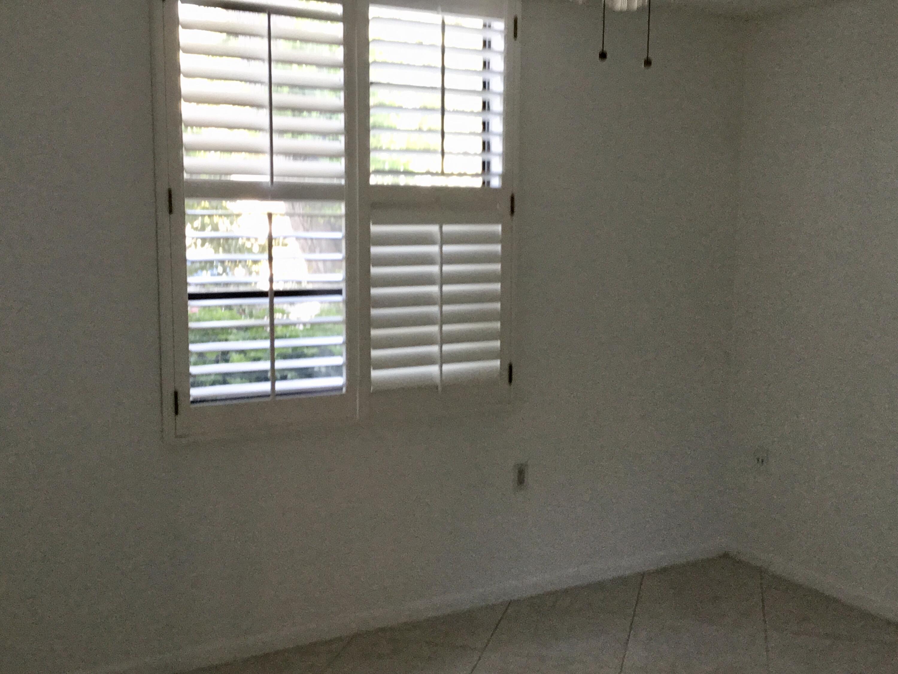 3636 Whitehall Drive, Unit 101 West Palm Beach, FL 33401 - Photo 14 of 16 an empty room with a window