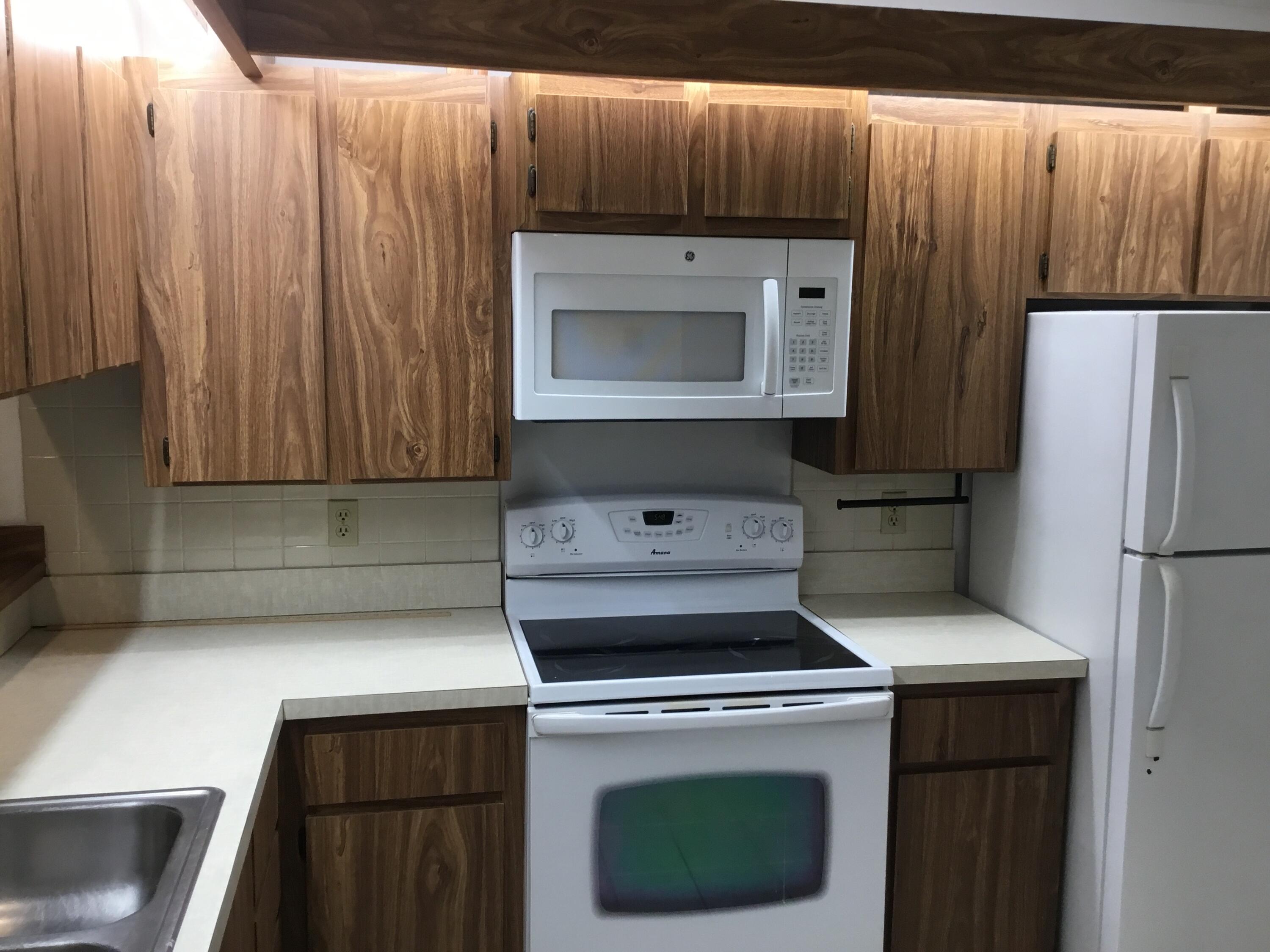 3636 Whitehall Drive, Unit 101 West Palm Beach, FL 33401 - Photo 4 of 16 a kitchen with a stove and a refrigerator