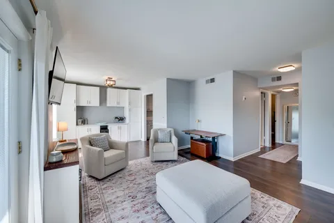 a living room with furniture and a wooden floor