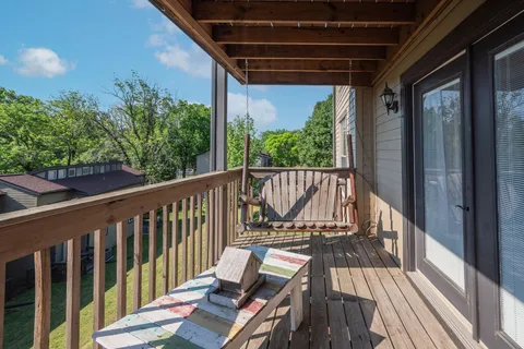 a view of balcony with wooden floor and iron fence