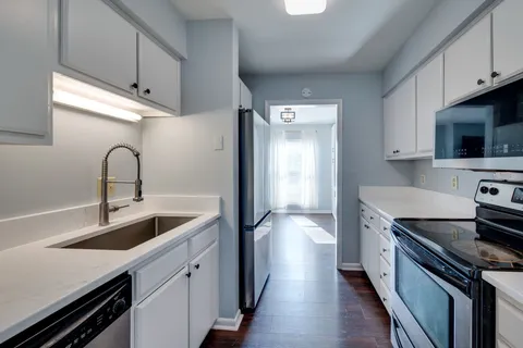 a kitchen with stainless steel appliances a sink stove and refrigerator