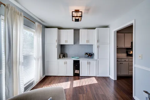 a kitchen with white cabinets and a window