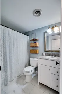 a spacious bathroom with a toilet a sink and a mirror