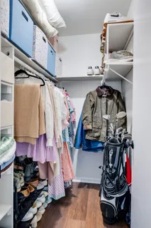 a view of walk in closet with clothes and shoes