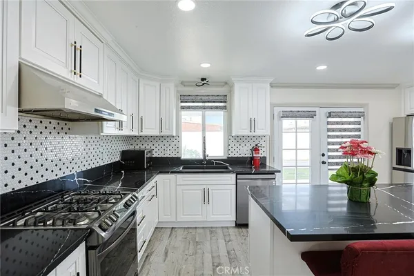 a kitchen with stainless steel appliances granite countertop a sink stove and cabinets