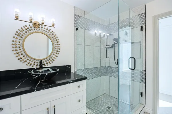a bathroom with a shower a mirror and a sink