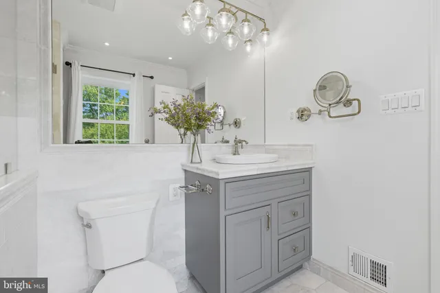 a bedroom with a bed a window and a flat screen tv