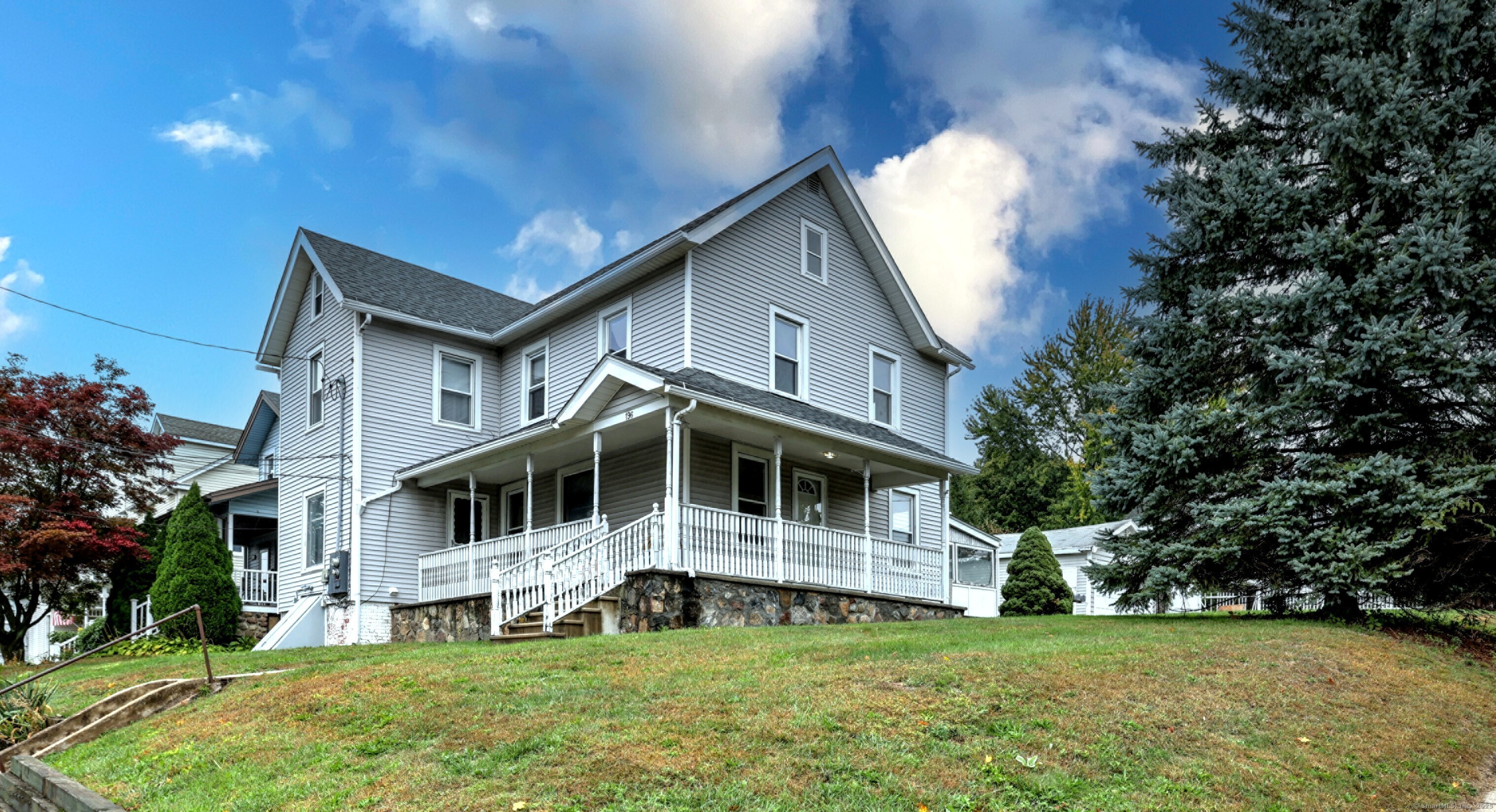 a view of a house with a big yard and large trees