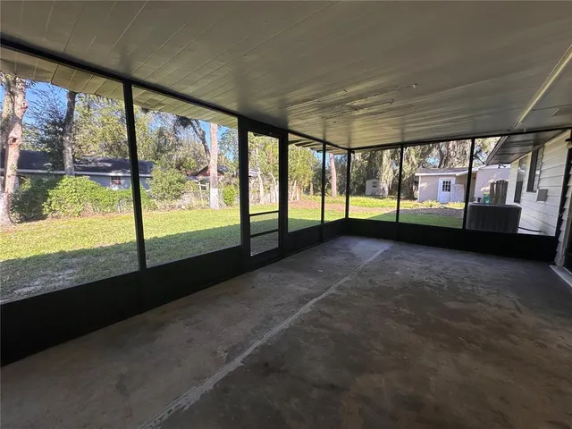 a view of an empty room with wooden floor and a floor to ceiling window