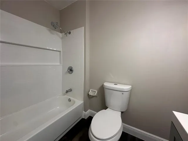 a white toilet sitting next to a bath tub