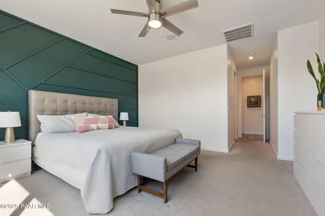 a bedroom with a bed and a ceiling fan