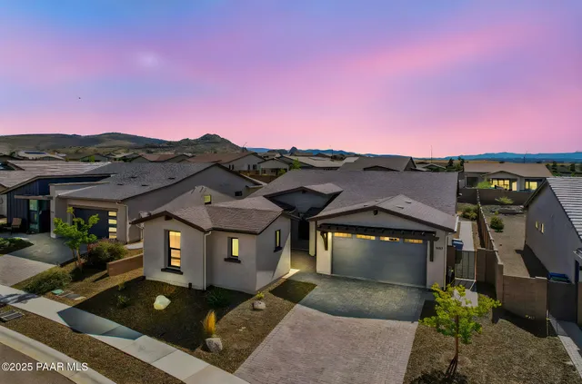 a front view of a house with a yard and mountain view