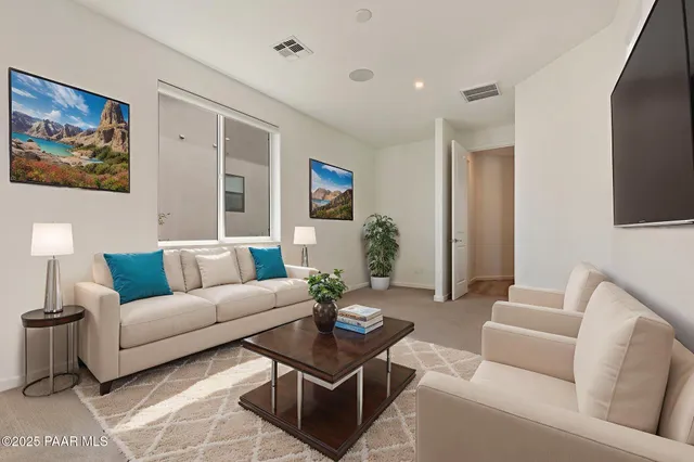 a living room with furniture a rug and a painting on the wall