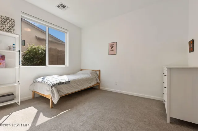 a bedroom with a bed rug and a window