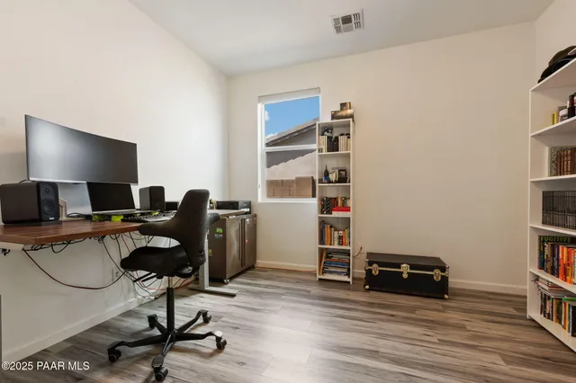 a view of a workspace with furniture and a book shelf