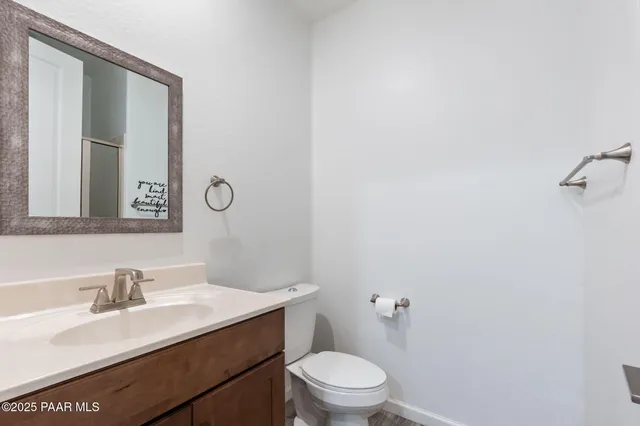a bathroom with a granite countertop sink mirror vanity and toilet