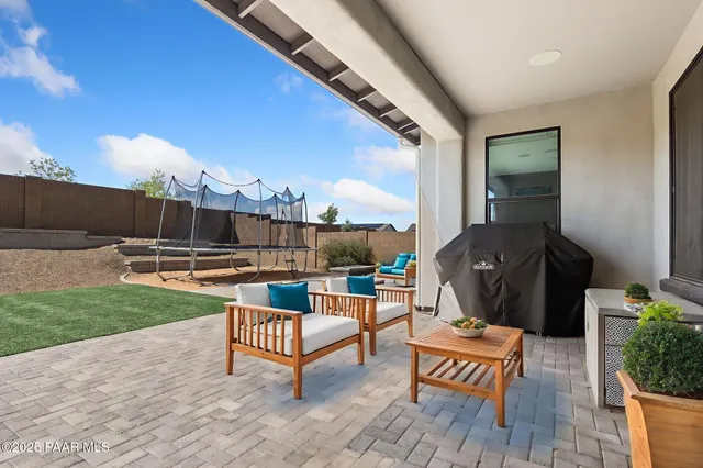 a roof deck with table and chairs and potted plants