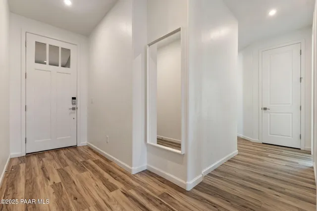 a view of a hallway with wooden floor and closet