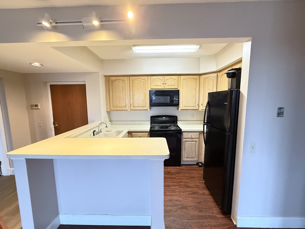 34 Sumner Avenue, Unit 311 Springfield, MA 01108 - Photo 2 of 8 a kitchen with a refrigerator and a sink