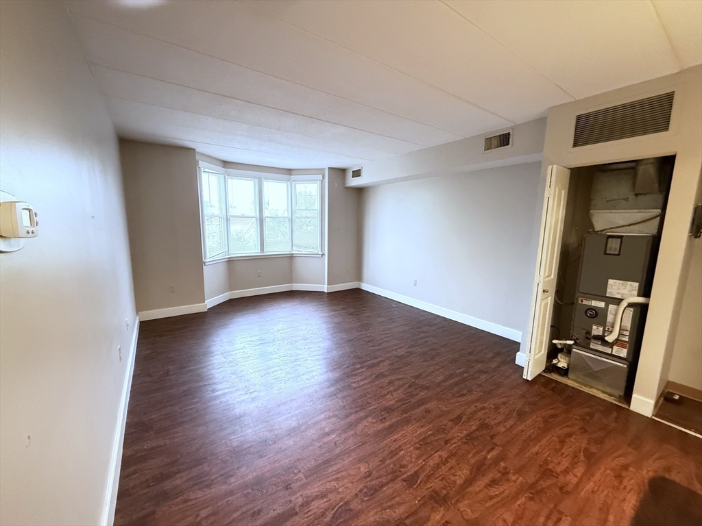 34 Sumner Avenue, Unit 311 Springfield, MA 01108 - Photo 3 of 8 an empty room with wooden floor and a window