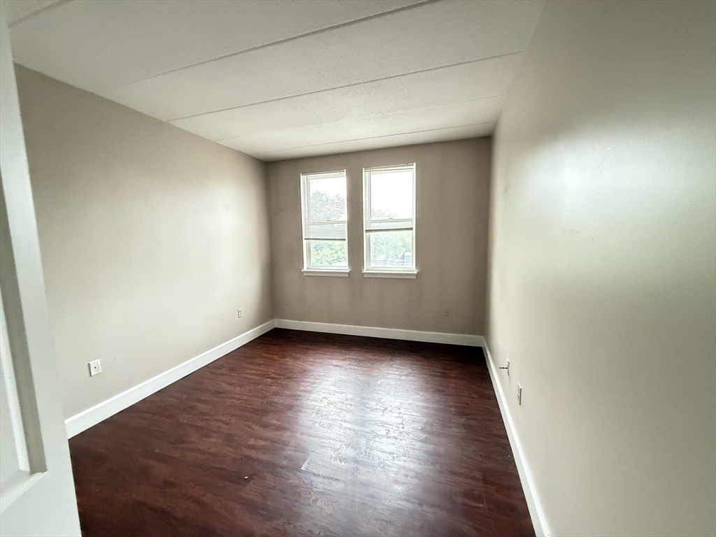 34 Sumner Avenue, Unit 311 Springfield, MA 01108 - Photo 4 of 8 an empty room with wooden floor and windows