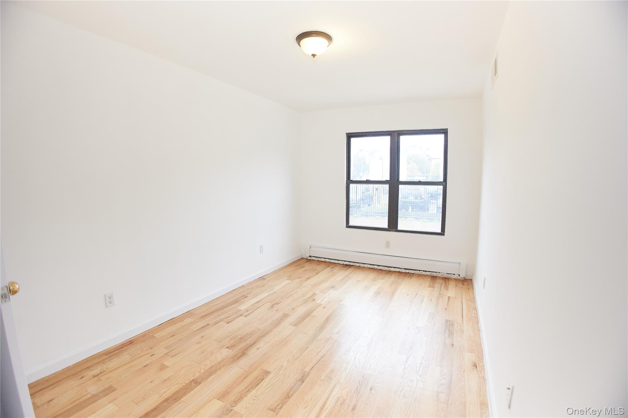 1292 Saint Marks Avenue, Unit 2 Brooklyn, NY 11213 - Photo 20 of 32 an empty room with wooden floor and windows