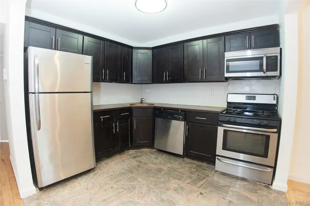 a kitchen with stainless steel appliances granite countertop a refrigerator stove a sink and a microwave