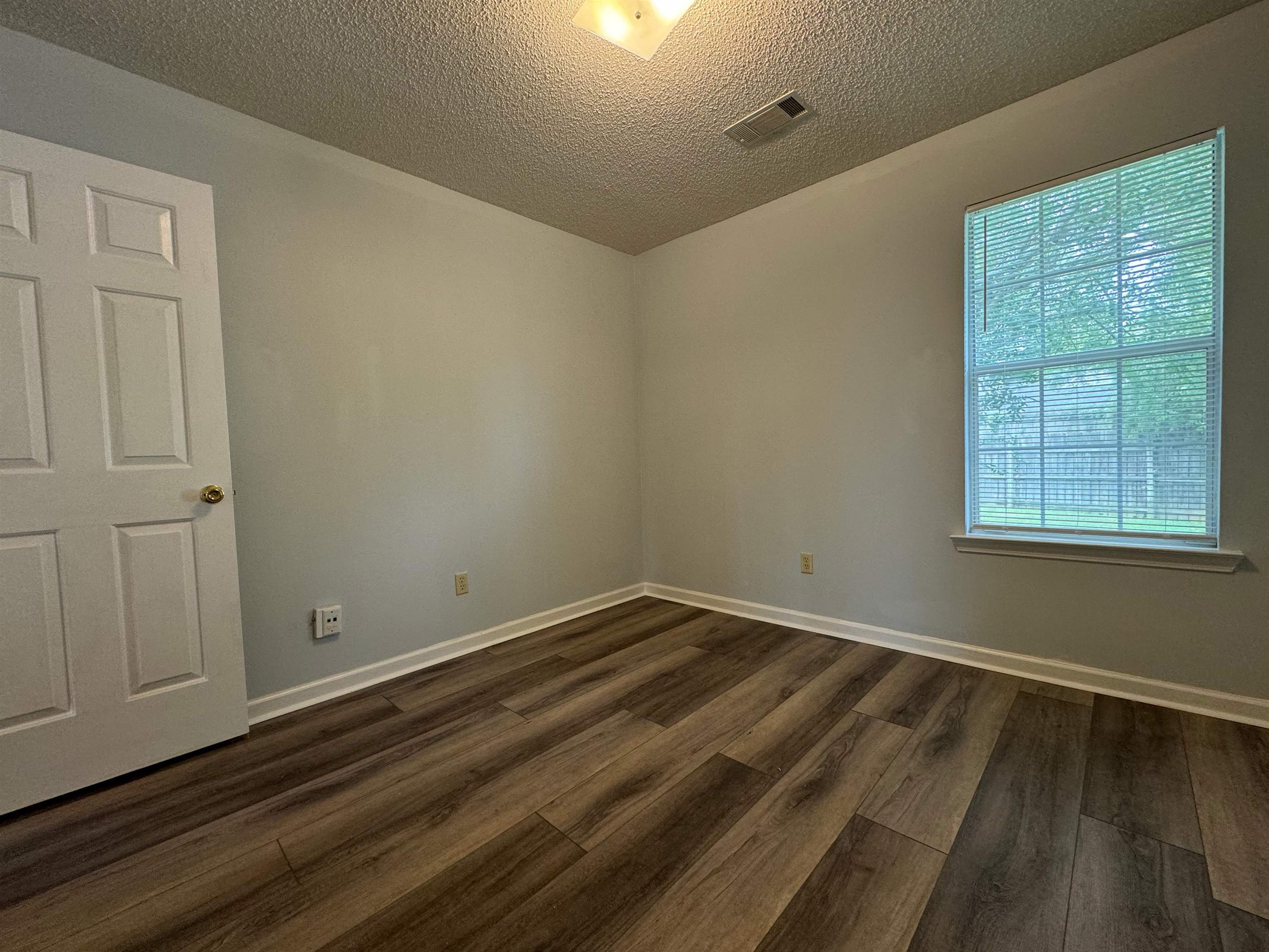 7083 Bryan Station Road Cordova, TN 38018 - Photo 18 of 19 Unfurnished room featuring a textured ceiling and dark hardwood / wood-style floors