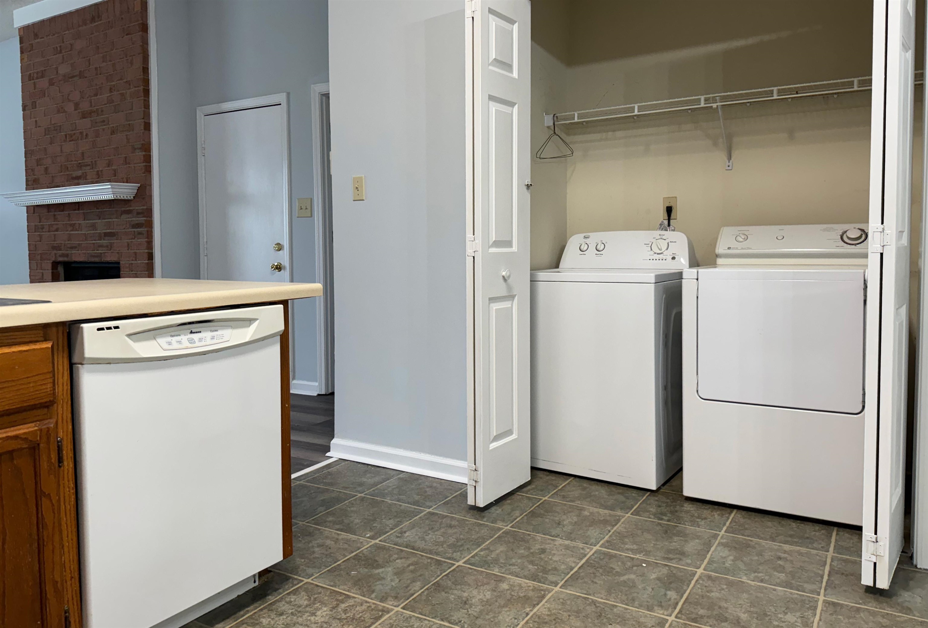 7083 Bryan Station Road Cordova, TN 38018 - Photo 10 of 19 Laundry area with dark tile patterned flooring and washing machine and dryer